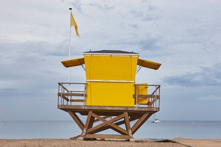 Lifeguard hut with yellow flag warning. Professional rescue assistanceの写真素材
