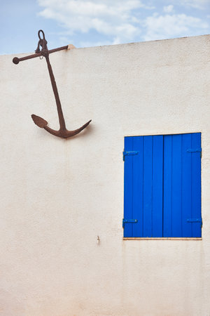 White building facade mediterranean style. Decorative rusty anchor. Spainの写真素材