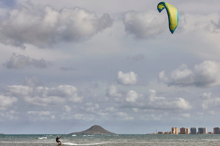 Mature man practicing kitesurfing. Aquatic sport. Athletic healthy senior male