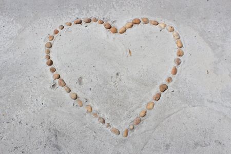Hearts of Stone Heart shaped stone on the cement floor の写真素材