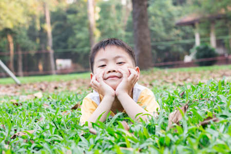 Portrait of a happy little boy in the parkの写真素材