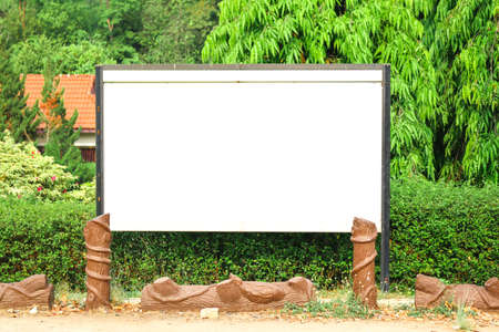 Blank billboard on green grass in park to place your logo or advertising on itの写真素材