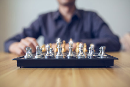 Strategic contemplation in action with a person making a chess move, focus on the golden and silver...
