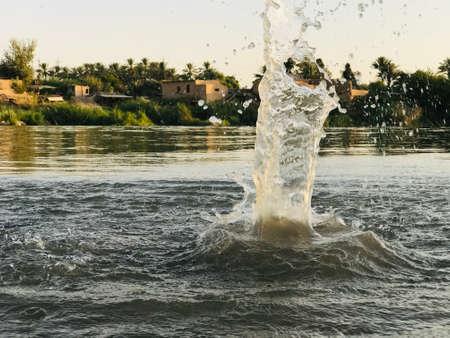 A water wave while a stone falls into the river waterの写真素材