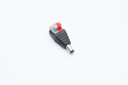 A DC power connector with black, red, and gray terminals, isolated on a white background. Ideal for...
