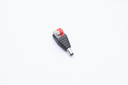 A DC power connector with black, red, and gray terminals, isolated on a white background. Ideal for...