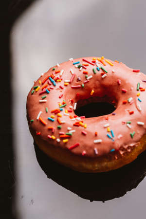 Fresh delicious donut with strawberry cream on a dark background.の写真素材