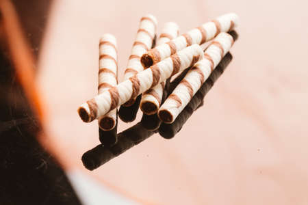 wafer rolls with nut filling on a dark mirror background.の写真素材