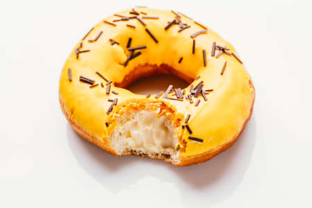 bitten donut with banana cream on a white background.の写真素材