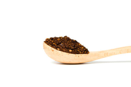 A chili flakes in a wooden spoon isolated over white backgroundの写真素材