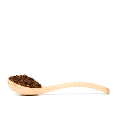 A chili flakes in a wooden spoon isolated over white backgroundの写真素材