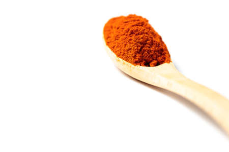 A chili powder in a wooden spoon isolated over white backgroundの写真素材