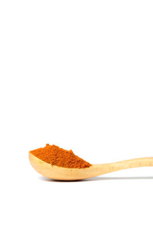 A curry powder in a wooden spoon isolated over white backgroundの写真素材