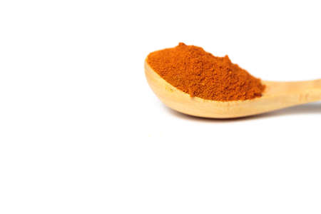 A curry powder in a wooden spoon isolated over white backgroundの写真素材