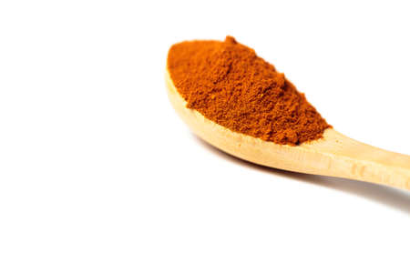 A curry powder in a wooden spoon isolated over white backgroundの写真素材