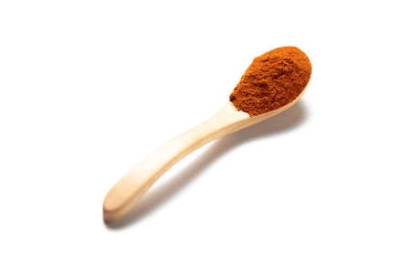 A curry powder in a wooden spoon isolated over white backgroundの写真素材