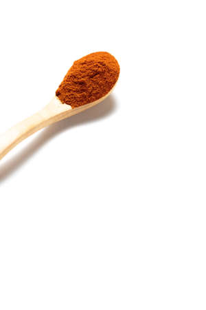 A curry powder in a wooden spoon isolated over white backgroundの写真素材