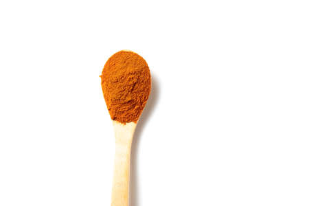A curry powder in a wooden spoon isolated over white backgroundの写真素材