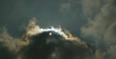 The sun is visible through thick clouds, cloudy weather