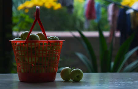 Apples in a plastic basket on the tableの写真素材