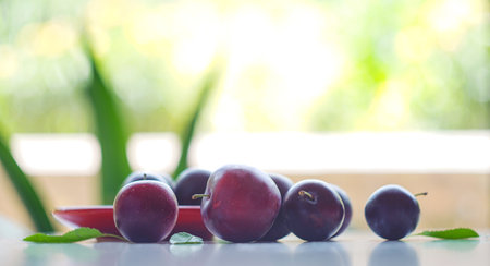 red plums in a red bowl, ripe plumsの写真素材