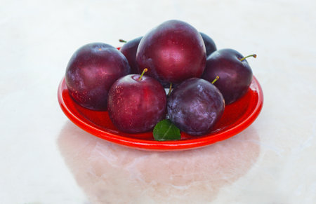 There are plums in the red bowlの写真素材