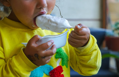 The girl eats ice cream, the girl smeared the ice cream on her faceの写真素材