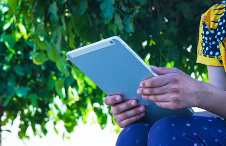 The girl is holding the gadgetの写真素材