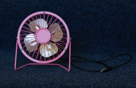 A small back color fan is standing on the groundの写真素材