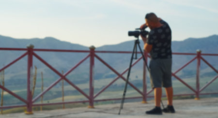 Bokeh shot of a guy with a camera on a tripodの写真素材