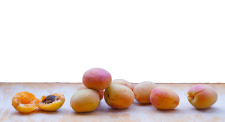Yellow apricots are scattered on the board in the bosom of nature