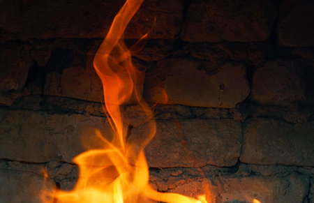 The fire burns red in the hearthの写真素材