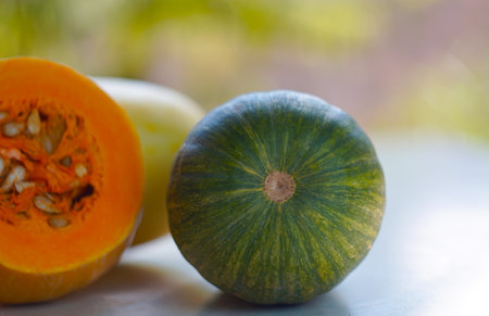 There are green and yellow pumpkins on the tableの写真素材
