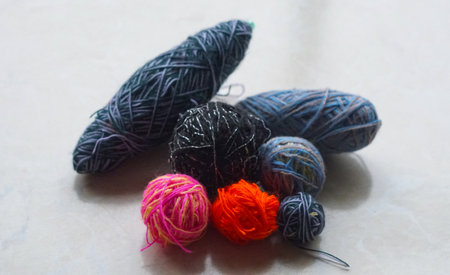 In front of the window, a row of colorful woolen threads stands.