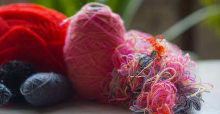 In front of the window, a row of colorful woolen threads stands.の写真素材