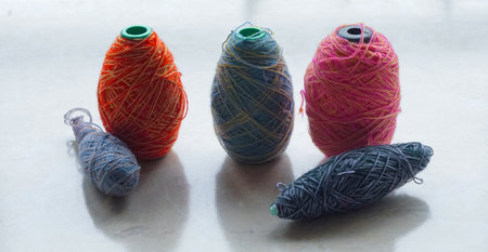 In front of the window, a row of colorful woolen threads stands.