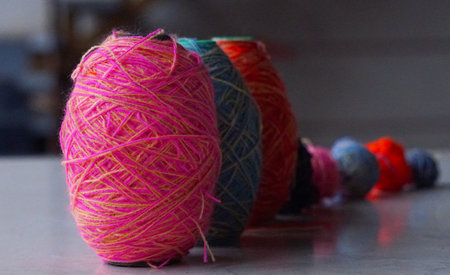 In front of the window, a row of colorful woolen threads stands.