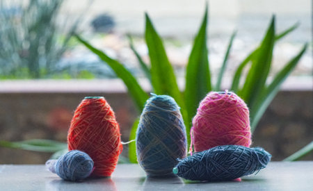 In front of the window, a row of colorful woolen threads stands.