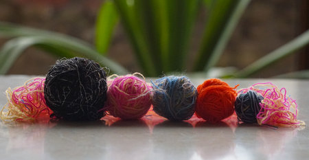 In front of the window, a row of colorful woolen threads stands.