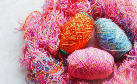 On the table, woolen threads of different colors stand in rows.