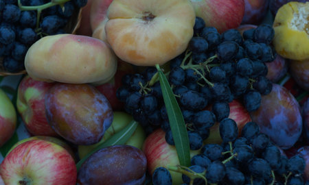There are red grapes and various fruits on the board.の写真素材