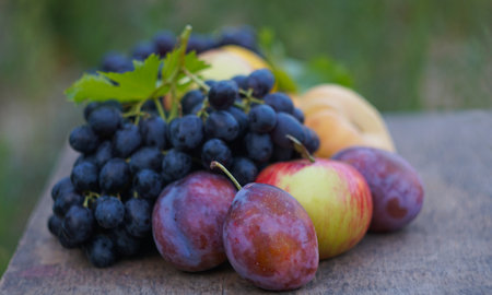 There are red grapes and various fruits on the board.の写真素材