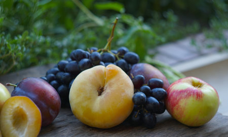 On the board are black grapes, yellow leaves, and various fruits.