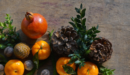 Tangerines and fir nuts on a wooden board create a table setting