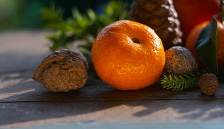 Tangerines and fir nuts on a wooden board create a New Year's table setting