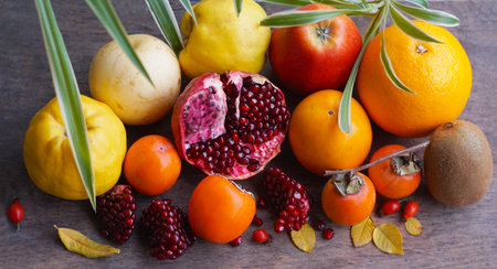 Flower petals hang over a piece of pomegranate and various fruits