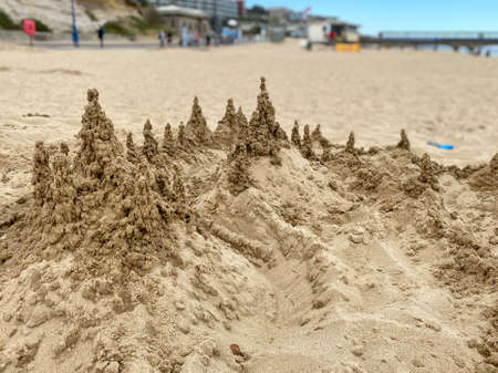 Artistic, abstract, and eerie sand-dripped sandcastle landscape on a hot sandy beach.の写真素材