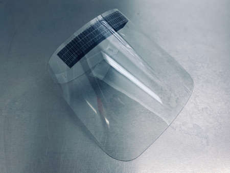 face shield visor on a stainless steel metal surgical table.の写真素材