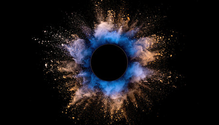 Colored dust explosion with blue and golden hues emanating from a central dark void on a black backdropの素材
