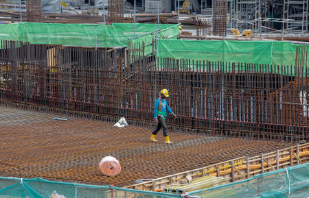 KUALA LUMPUR, MALAYSIA - AUGUST 10, 2016: Builder worker in safety protective equipment walk on concrete steel slab at building construction site.のeditorial素材